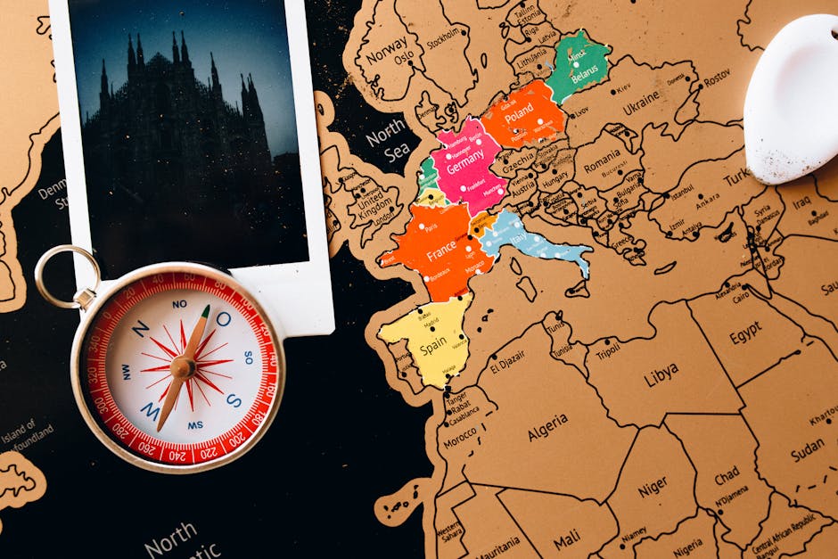 Close-up of a map with a compass and a photo of a cathedral in Europe.